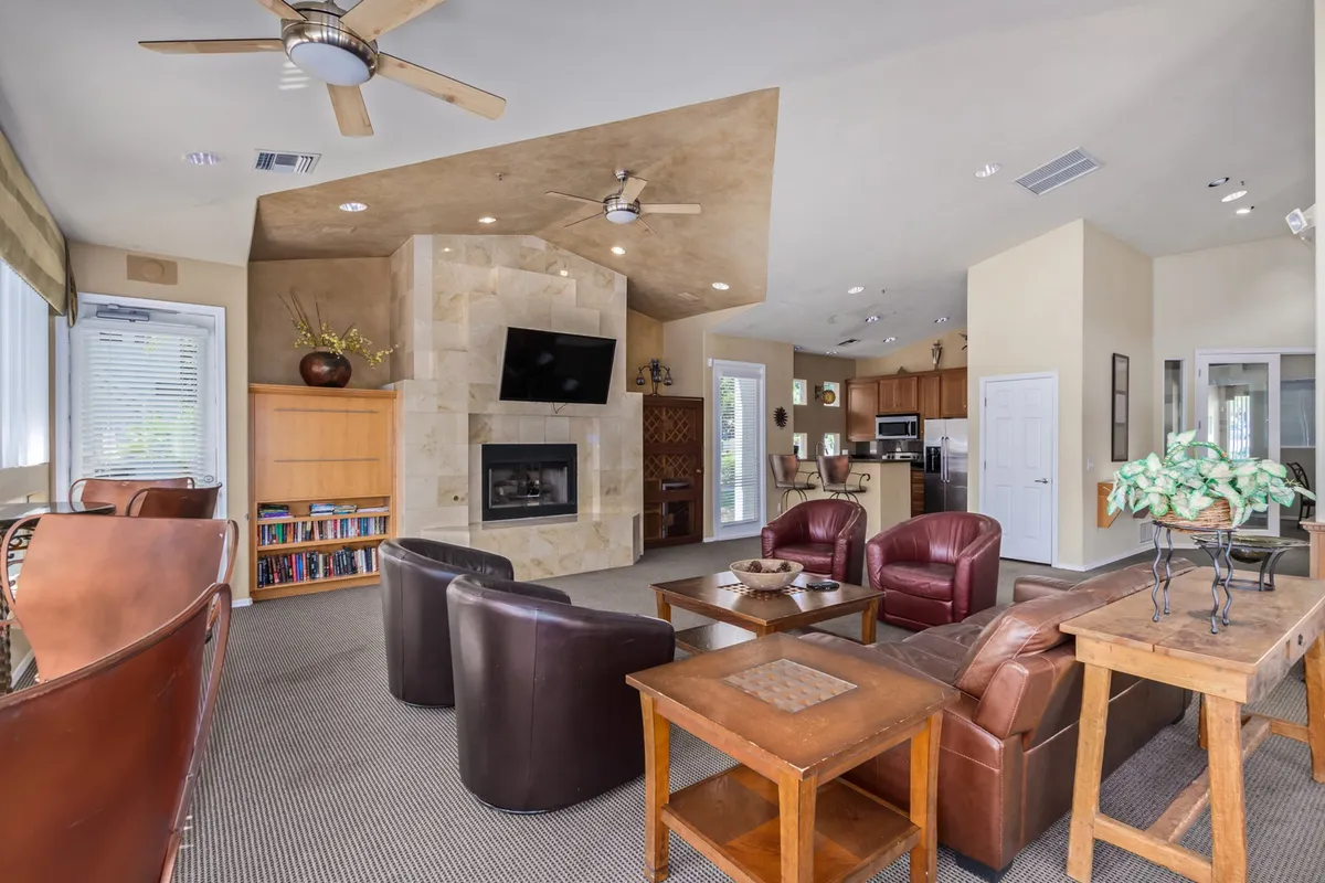 A cozy living room featuring a contemporary fireplace, ample seating, and an open view of the kitchen. The space is designed for relaxation, gatherings, and winding down after a day out.